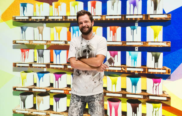 istock Caucasian male painter in the store and holding paint roller 1245041441