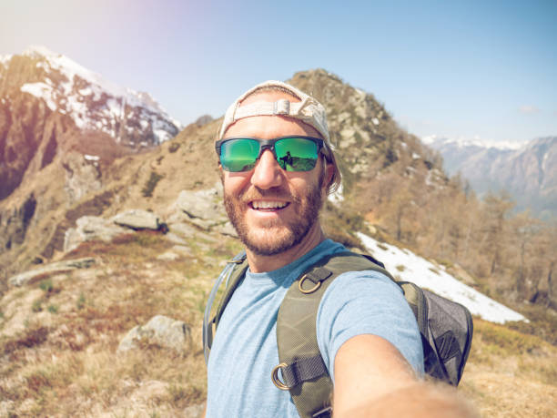 istock Cheerful young man taking a selfie portrait on mountain top 1245041794