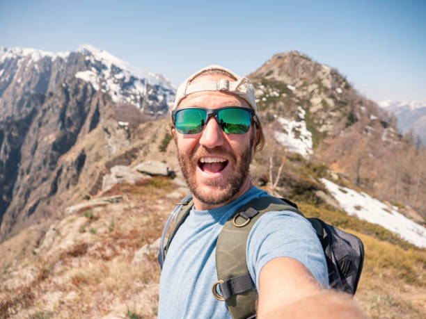 istock Cheerful young man taking a selfie portrait on mountain top 1245041975