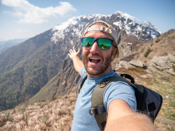 istock Cheerful young man taking a selfie portrait on mountain top 1245042187