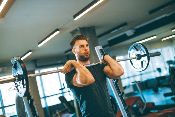 istock Young man working out with barbells in the gym 1245043468