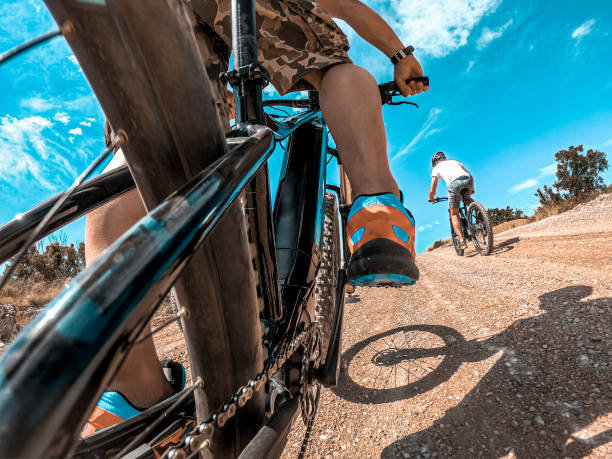un punto de vista de acción de un ciclista montando una e-bike en una carrera por el lado del país en un día soleado - bicycle chain bicycle gear chain gear fotografías e imágenes de stock