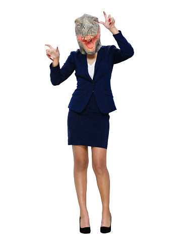 Front view of aged 20-29 years old who is beautiful with long hair latin american and hispanic ethnicity young women businesswoman standing in front of white background wearing mask - disguise and high heels and wearing wearing dinosaur mask mask