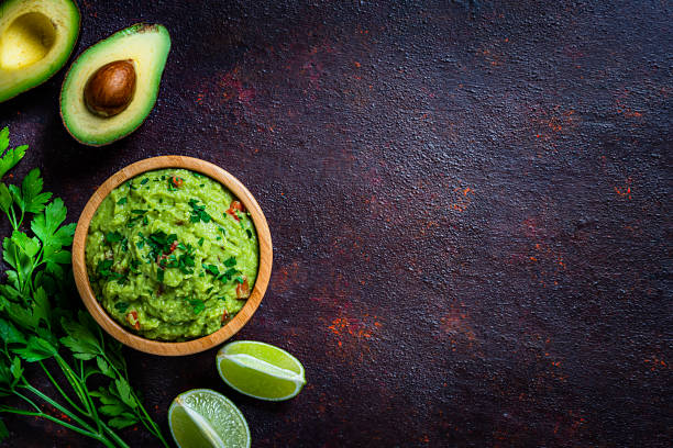 guacamole e chips filmados de cima na mesa marrom escura. copiar espaço - guacamole mexican cuisine avocado food - fotografias e filmes do acervo