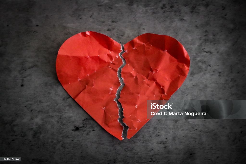 Red paper heart broken Red paper heart ripped in half on dark background. Broken heart separation concept Broken Heart Stock Photo