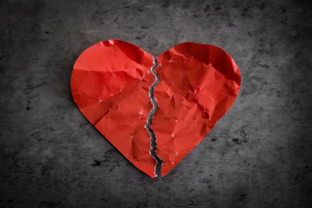 Red paper heart broken Red paper heart ripped in half on dark background. Broken heart separation concept relationship breakup photos stock pictures, royalty-free photos & images