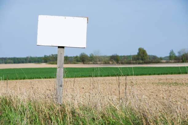 istock A blank white sign is in front of the land. 1245094298