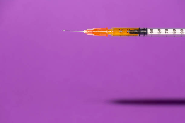 istock Syringe on purple color background 1245094326