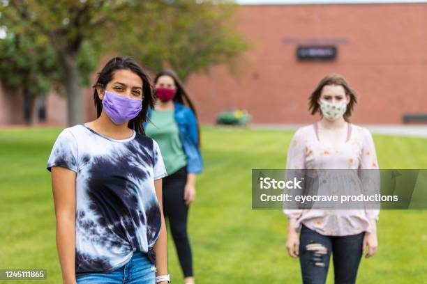 Group Of Generation Z Multiethnic Female Friends Wearing Face Masks And Social Distancing Stock Photo - Download Image Now