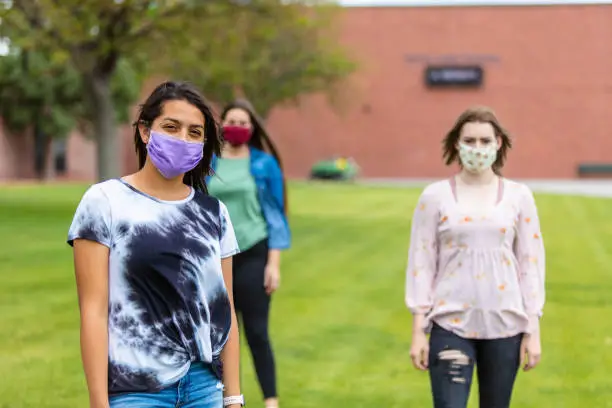 Photo of Group of Generation Z Multi-Ethnic Female Friends Wearing Face Masks and Social Distancing