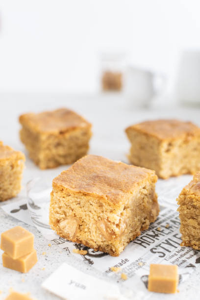 Close up of toffee caramel blondies, sweet pastry on light table Close up of toffee caramel blondies, sweet pastry on light table, copy space blondy stock pictures, royalty-free photos & images