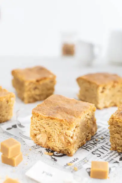 Close up of toffee caramel blondies, sweet pastry on light table, copy space