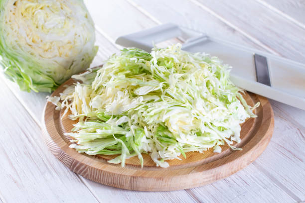 istock Sliced fresh cabbage on a cutting board with a grater on a wooden background 1245117572