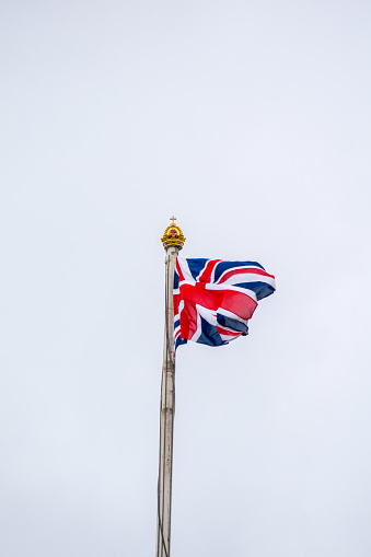 China and Britain flags against blue sky background