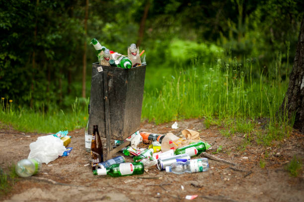 uma lata de lixo transbordante em um parque de recreação no auge de uma infecção por coronavirus. - dirty bench empty park - fotografias e filmes do acervo