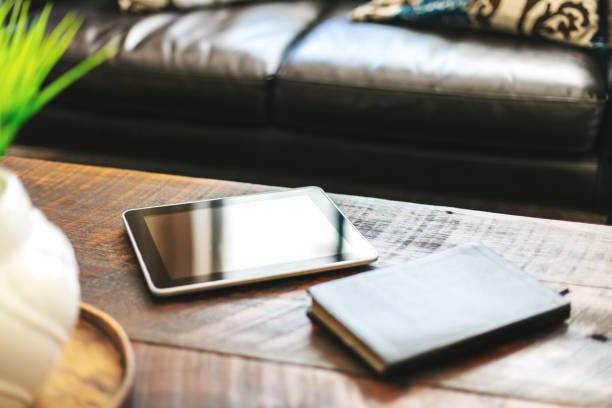 istock Digital Tablet and Bible on Rustic Wood Coffee Table in Living Room 1245149788