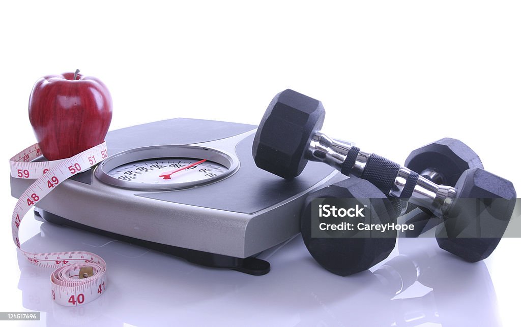 diet, exercise and weight loss a scale with apple and tape measure and dumbells on plexi glass Apple - Fruit Stock Photo