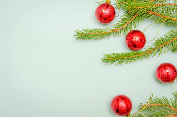 istock Christmas tree branches with red balls on a light blue background, copy space. Christmas background with copy space. view top 1245182774