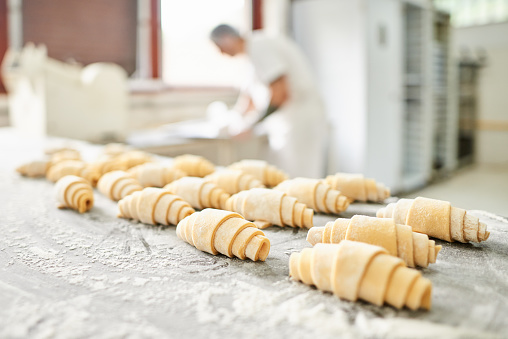 Woman making delicious baklava at wooden table, closeup