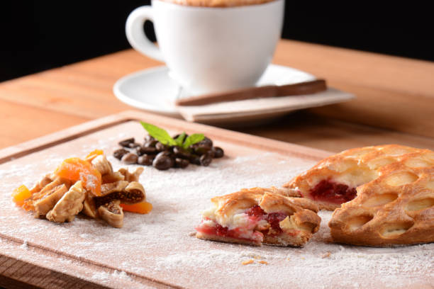 A traditional Swedish pastry paired with a double espresso coffee cup, placed elegantly on a textured linen material on a wooden table. Photographed with a very shallow depth of field for a soft feeling.