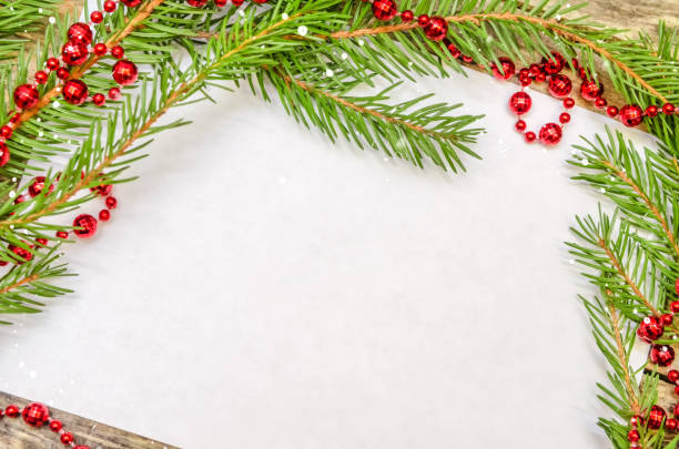 istock White leaf on wooden background with Christmas tree branches and red beads close up with copy space. Beautiful Christmas background or greeting card 1245226577