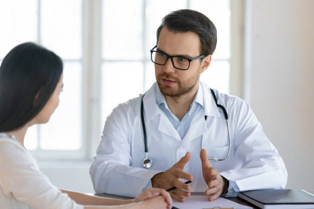 istock Male GP talk at consultation with female client 1245229239
