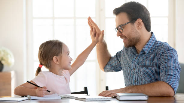 istock Happy dad and small daughter celebrate success studying together 1245229328
