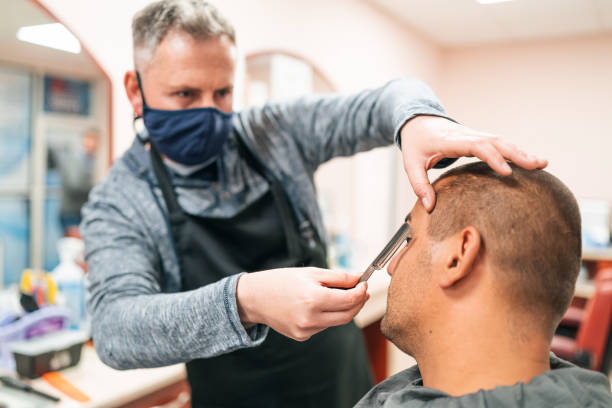 istock Barber with face mask shaving customer during COVID-19 1245229661