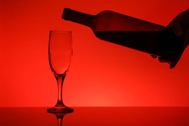 bottle of wine and glass on red background
