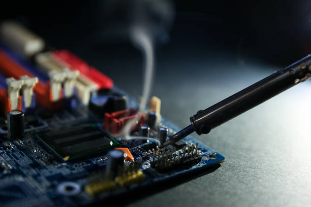 istock backdrop of smoking soldering iron and computer board 1245234253