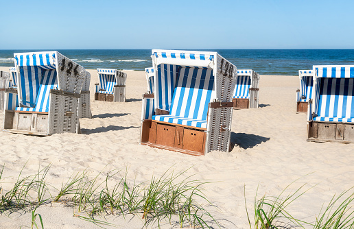 Hooded beach chairs and breaking waves at the sand beach of Hoernum in the evening light. Sylt, North Frisian Islands, Schleswig-Holstein, Germany