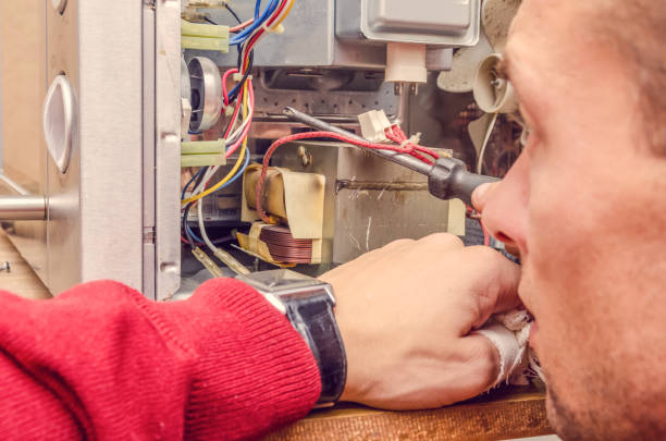 istock master man repairs microwave oven in the workshop 1245267522