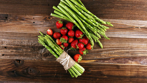 istock green asparagus with strawberries on wooden table 1245271335