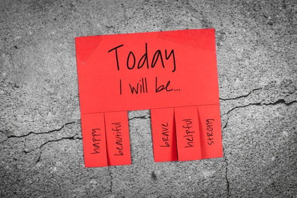istock Red tear-off stub note with text 'Today I will be...' and words 'happy, beautiful, brave, helpful' and 'strong' on concrete wall background 1245271459