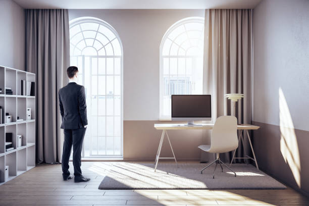 istock Businessman standing in office interior with city view 1245277513