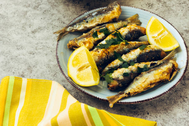 istock fried sardines on the plate decorated with lemon and parsley 1245281373