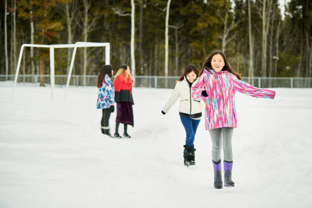 istock Girls having fun on snowy school field 1245301416