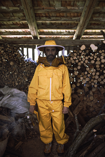 A beekeeper at work: portrait of a beekeeper with the specific suit and the smoker in his hand