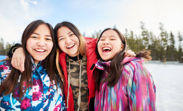 Friends together at recess Portrait of young school girls in warm clothing looking at camera and smiling in the winter indigenous peoples of the americas stock pictures, royalty-free photos & images