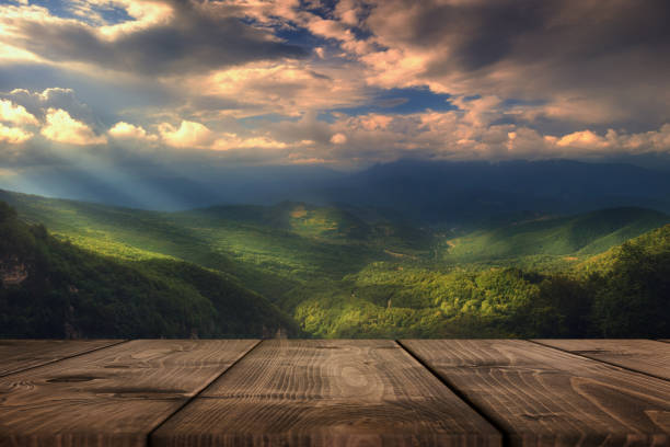 istock Rays of light pass through the clouds, Summer beautiful background with empty wooden table. Natural template landscape 1245330104