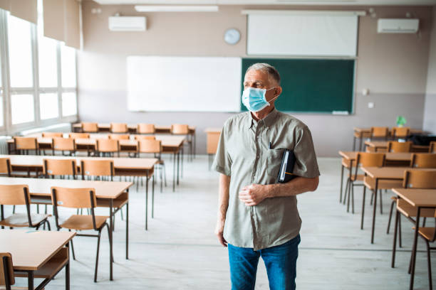 Teacher in an empty classroom stock photo