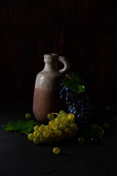 Fresh blue and green grapes with leaves. Grapes and jug