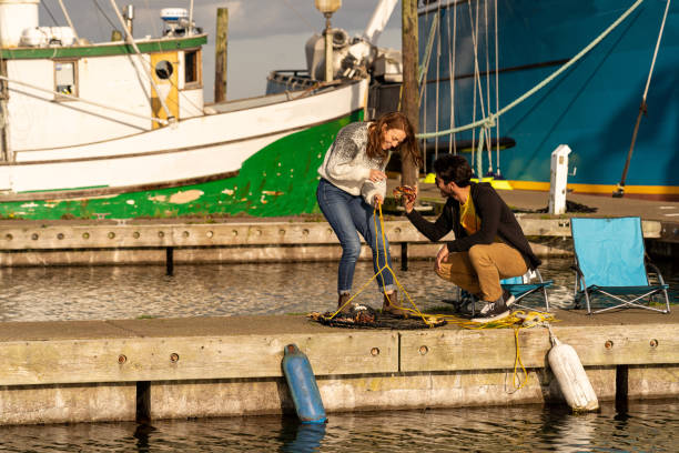 istock Young woman sets up crabbing nets on pier 1245369118