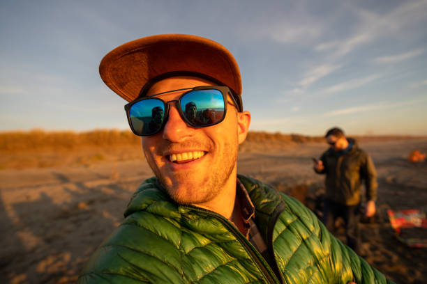 istock Man relaxes by riverbank in the morning 1245377554