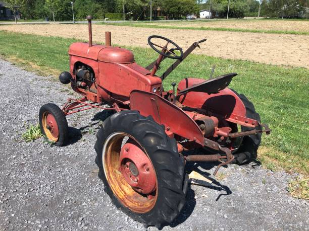 old vintage rusty red tractor with black wheels 3 - agricultural machinery retro revival summer farm imagens e fotografias de stock