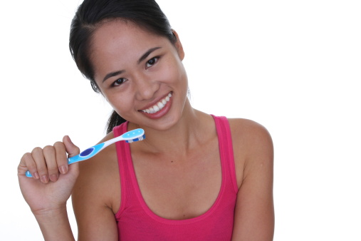 smiling woman brushing her teeth