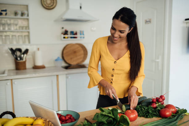 istock Cheerful young woman preparing food and vlogging 1245410065