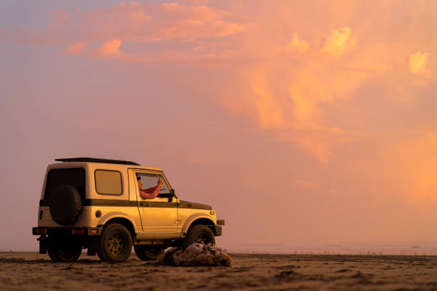 istock Friends drive along sandy beach at sunrise 1245412503
