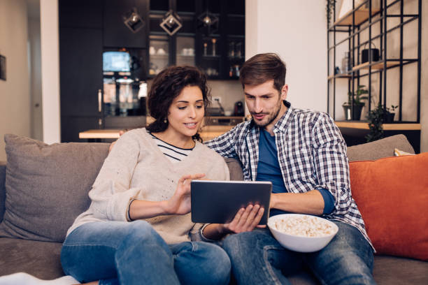 istock Couple enjoying their evening on the sofa, watching something on tablet 1245463743