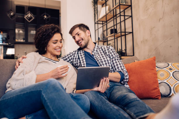 istock Couple enjoying on the sofa, watching something on tablet 1245463792